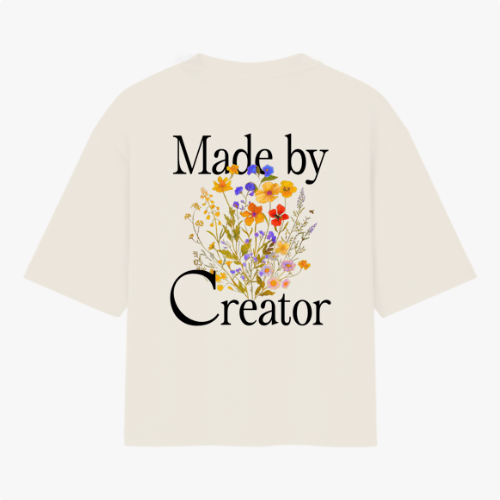 Camiseta com estampa frontal de "Made by Creator" em letras estilizadas e estampa traseira de "Made by Creator" acompanhada por ilustração de flores coloridas.