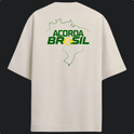 Camiseta com estampa frontal de contorno do mapa do Brasil e texto "Acorda Brasil" abaixo. Estampa traseira apresenta o mesmo design ampliado.