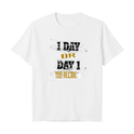 Camiseta com estampa frontal de texto em fontes variadas: "1 DAY OR DAY 1 YOU DECIDE", combinando estilos desgastados em branco e dourado.