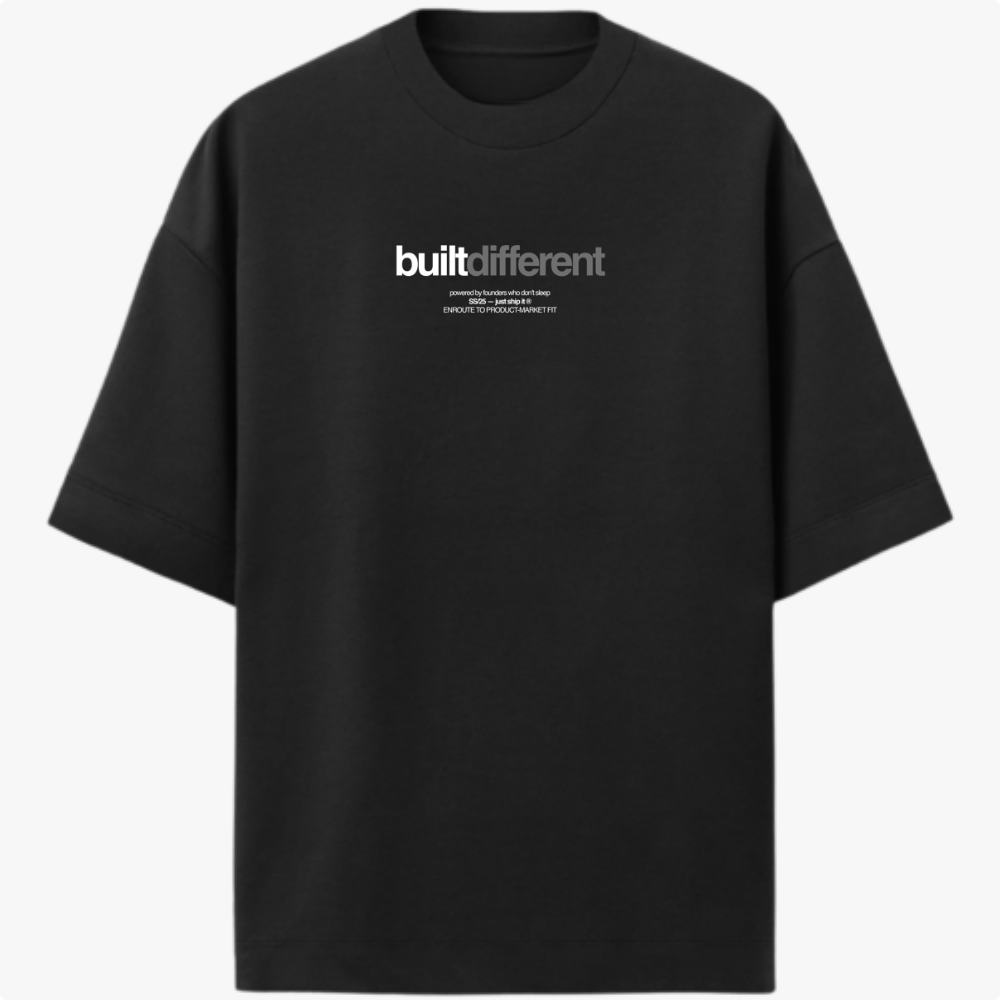 Camiseta com estampa frontal de texto "built different" em destaque, acompanhado por linhas menores com frases adicionais, em um estilo moderno e impactante.