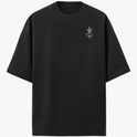 Camiseta com estampa frontal de símbolo detalhado no peito e estampa traseira de figura humana em pose de combate com rosto ameaçador ao fundo.