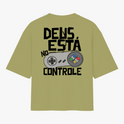 Camiseta com estampa frontal de logo pequeno escrito “VIGIA” no centro e estampa traseira de controle de videogame com frase “DEUS ESTÁ NO CONTROLE”.
