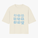 Camiseta com estampa frontal de nove rostos de gatos variados, um deles usando óculos, e estampa traseira de um rosto de gato com expressão séria.