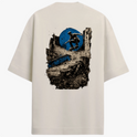 Camiseta com estampa frontal de logo minimalista circular e estampa traseira de skatista sobre ruínas urbanas e círculo abstrato.