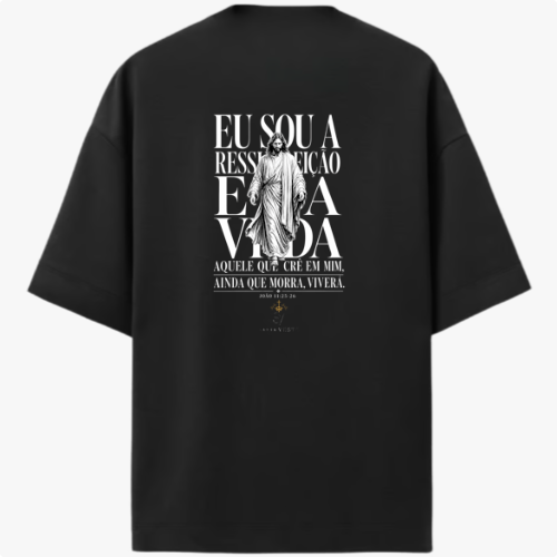 Camiseta com estampa traseira de uma figura central religiosa e frase que menciona ressurreição e vida, cercada por texto estilizado.