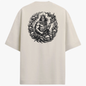 Camiseta com estampa frontal de montanha e texto sob ela, e estampa traseira detalhada de figura mitológica central cercada por caveiras e chamas.