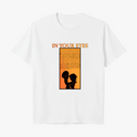 Camiseta com estampa frontal de duas silhuetas perfiladas em preto contrastando sobre fundo alaranjado, sob texto "IN YOUR EYES" em letras grandes.