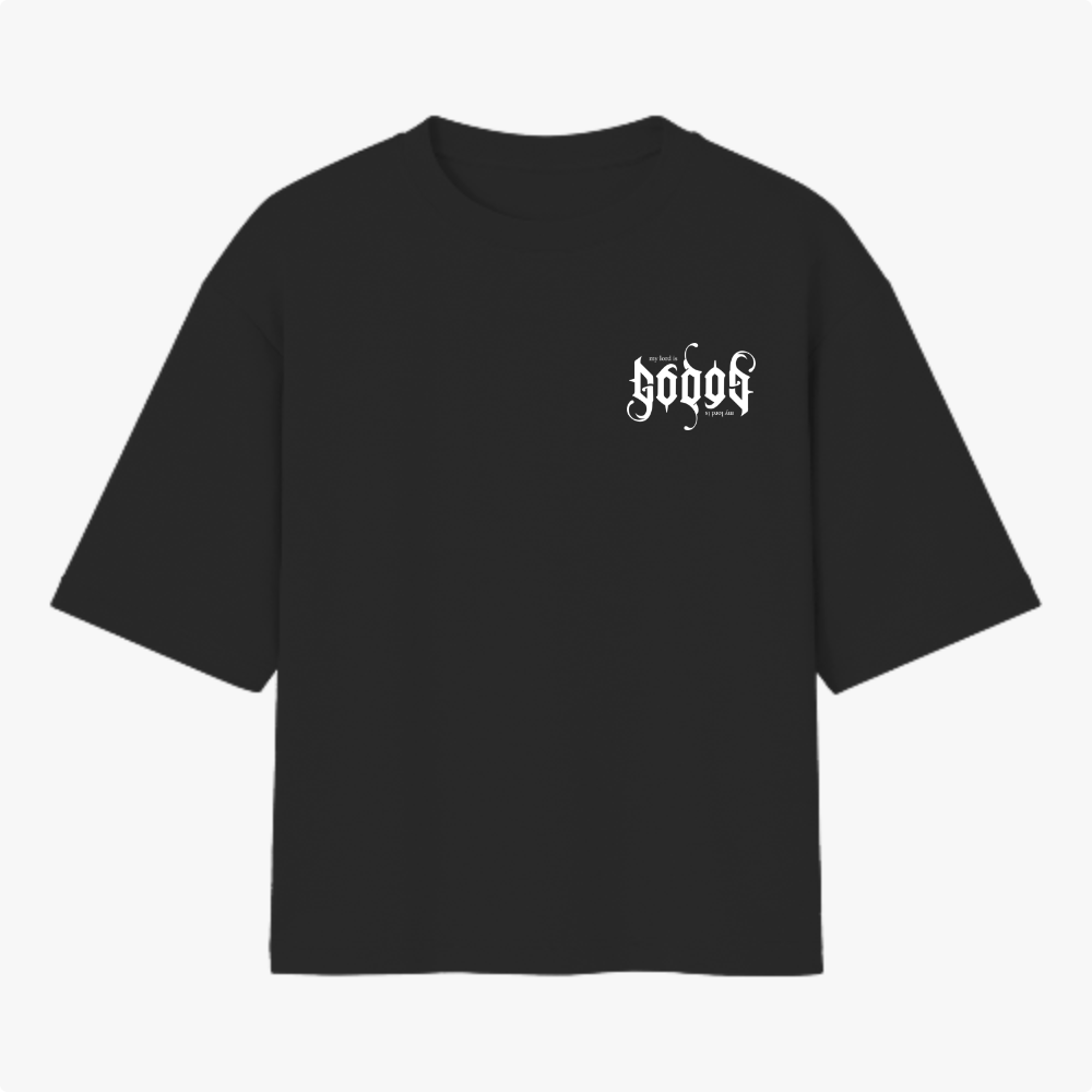 Camiseta com estampa frontal de texto estilizado em letras góticas com frase "my lord is" e estampa traseira maior replicando o mesmo texto.