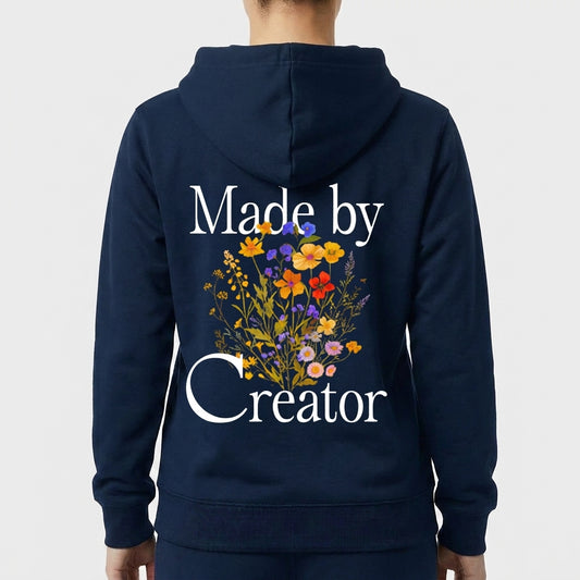 Moletom com estampa frontal de texto "Made by Creator" discreto no peito e estampa traseira com texto maior "Made by Creator" e arranjo de flores diversas.