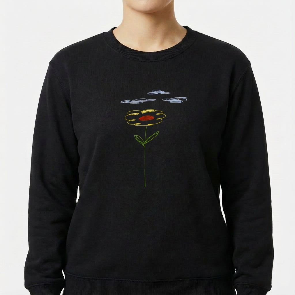 Moletom com estampa frontal de desenho estilizado de flor com pétalas contornadas por linhas, centro circular destacado e folhas, sob nuvens desenhadas.