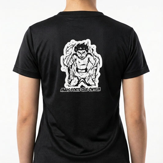 Camiseta com estampa traseira de um personagem com expressão intensa e cabelos espetados, rodeado por um contorno, acompanhada da frase "MAIS FORTE QUE ONTEM".
