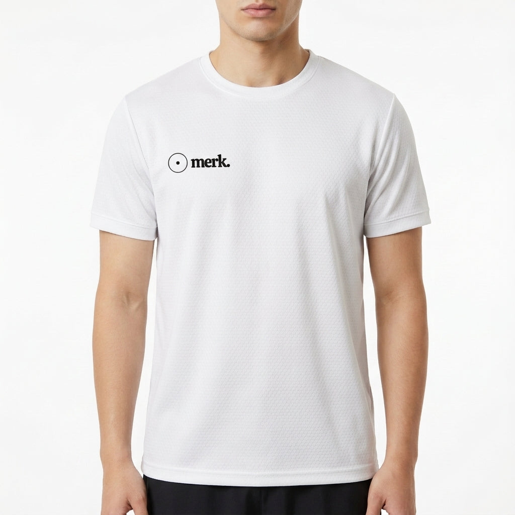 Camiseta com estampa frontal de logotipo estilizado incluindo texto "merk." e estampa traseira de interseção de dois círculos com textos "vesica piscis." e "ventre do universo".