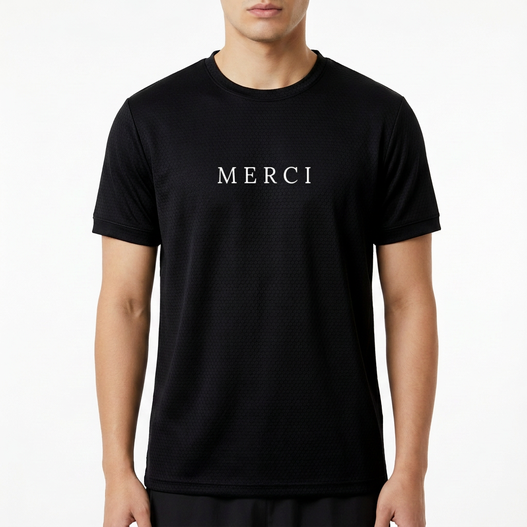 Camiseta com estampa frontal da palavra "MERCI" em letras maiúsculas, com um design simples e sofisticado que destaca a mensagem no centro.