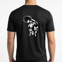 Camiseta com estampa frontal de personagem de mangá com cabelo desgrenhado e expressão séria, destacando músculos definidos e pose imponente.