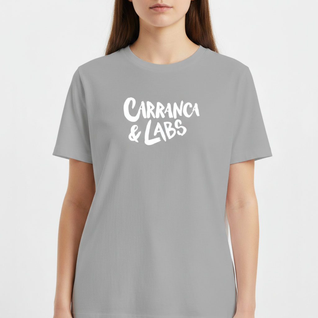 Camiseta com estampa frontal de letras estilizadas "Carranca & Labs" e estampa traseira de um desenho gráfico de figura caricata com expressão marcante.