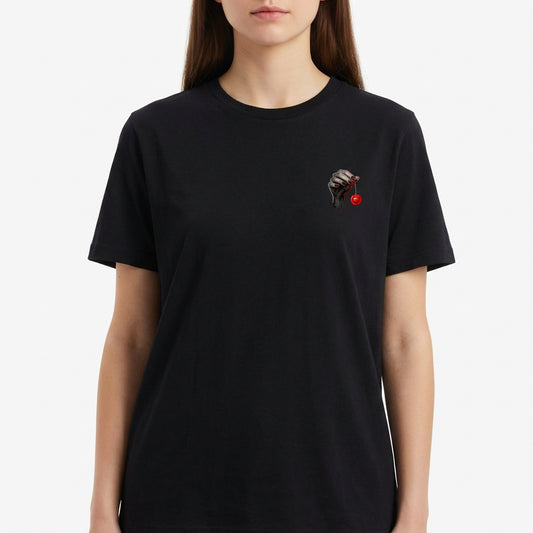 Camiseta com estampa frontal de uma mão esquelética segurando um cordão que pende uma bola vermelha, sugerindo um visual misterioso e intrigante.