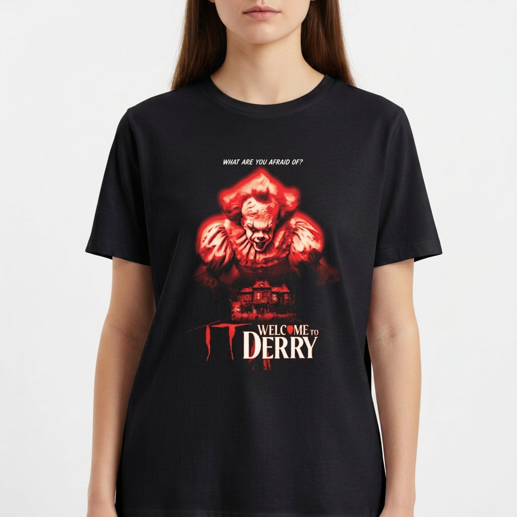 Camiseta com estampa frontal de criatura monstruosa acima de uma casa sombria, com a frase "What are you afraid of?" e "Welcome to Derry" em destaque.