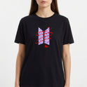 Camiseta com estampa frontal de nomes sobrepostos em negrito, com linhas curvas ao redor e assinatura na base criando um visual dinâmico e moderno.