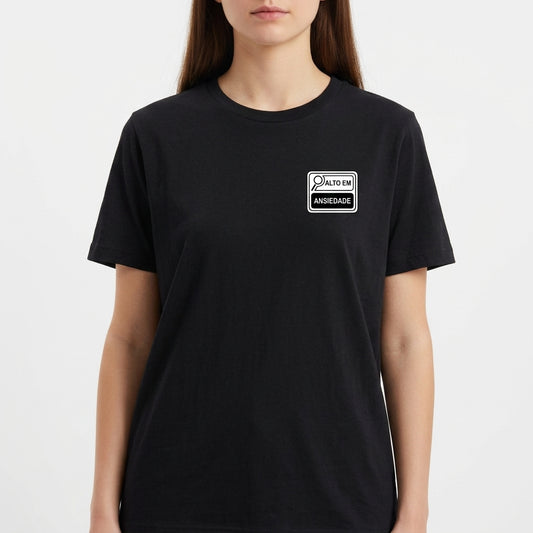 Camiseta com estampa frontal de um selo estilo rótulo de produto com os dizeres "ALTO EM ANSIEDADE", incluindo ilustração de uma lupa.