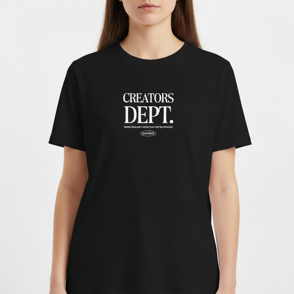 Camiseta com estampa frontal de texto "CREATORS DEPT." em fonte estilizada, acompanhado por uma frase descritiva e logotipo ovalado na parte inferior.