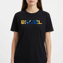 Camiseta com estampa frontal de "BRASIL" em letras preenchidas por elementos gráficos variados e estampa traseira discreta com a frase "AGTBB FBRKM 100".