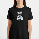 Camiseta com estampa frontal de gamepad com botões coloridos abaixo da frase "DEUS ESTÁ NO", acompanhada de referência textual "1 Coríntios 2:9".