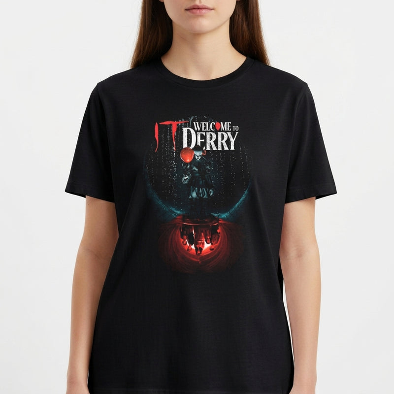 Camiseta com estampa frontal de texto "Welcome to Derry" acima de um balão flutuante, com silhuetas refletidas em um fundo iluminado.