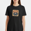 Camiseta com estampa frontal de um selo retangular retrô com o ano "1986" no topo e a inscrição "Rede Manchete" abaixo, separado por um símbolo estilizado.