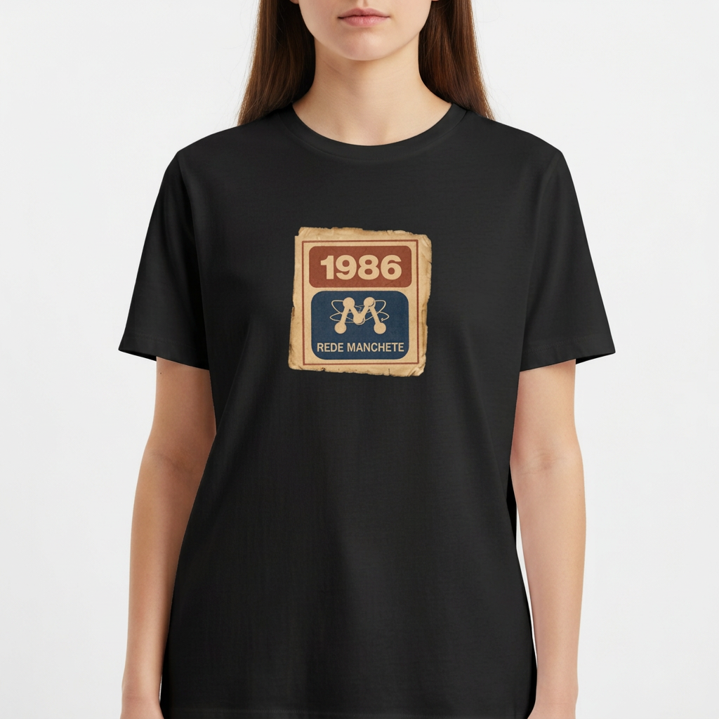 Camiseta com estampa frontal de um selo retangular retrô com o ano "1986" no topo e a inscrição "Rede Manchete" abaixo, separado por um símbolo estilizado.