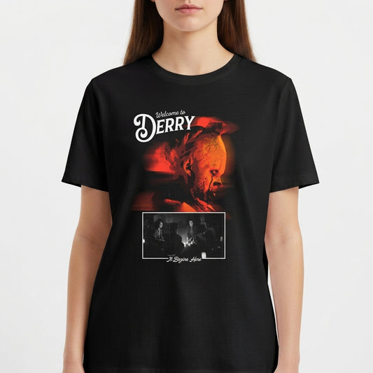 Camiseta com estampa frontal de uma figura teatral com cabeça de palhaço iluminada, texto "Welcome to Derry" e cena inferior de três músicos com texto "A Deeper Love".