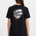 Camiseta com estampa frontal de texto estilizado pequeno no peito e estampa traseira de grande texto artístico com efeito de respingos e escorridos.