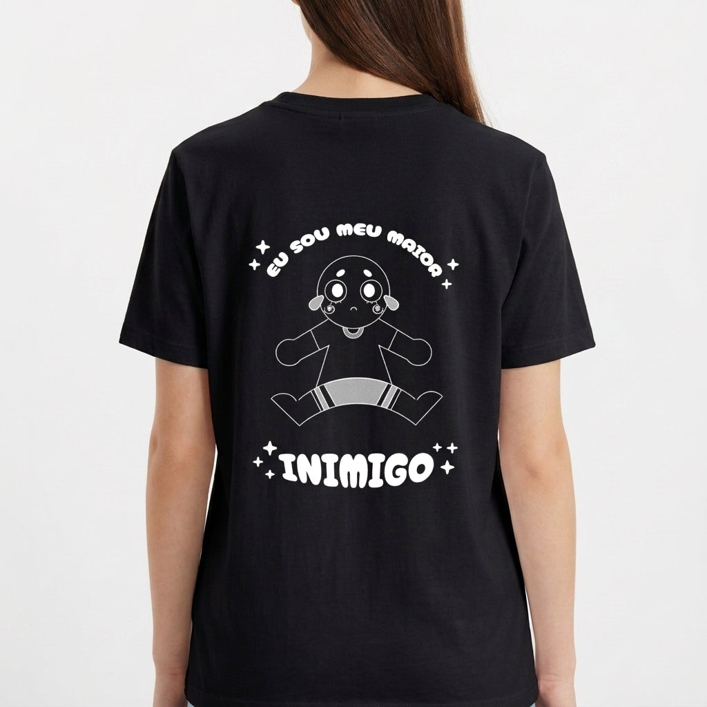 Camiseta com estampa frontal de pequeno disco voador minimalista e estampa traseira de personagem desenhado, com dizeres "Eu sou meu maior inimigo" em destaque.