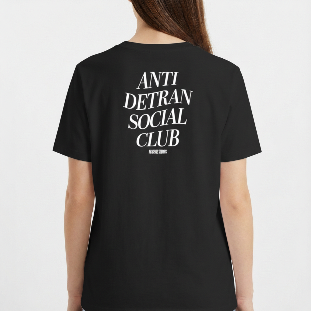 Camiseta com estampa frontal de escrita "ANTI DETRAN SOCIAL CLUB" e estampa traseira maior com a mesma mensagem, acompanhada por "NO BREAK STUDIOS".
