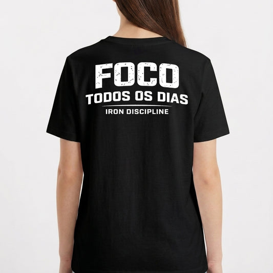Camiseta com estampa frontal de "IRON Discipline" com halteres e estampa traseira de "FOCO TODOS OS DIAS" sobre "IRON DISCIPLINE" em letras destacadas.