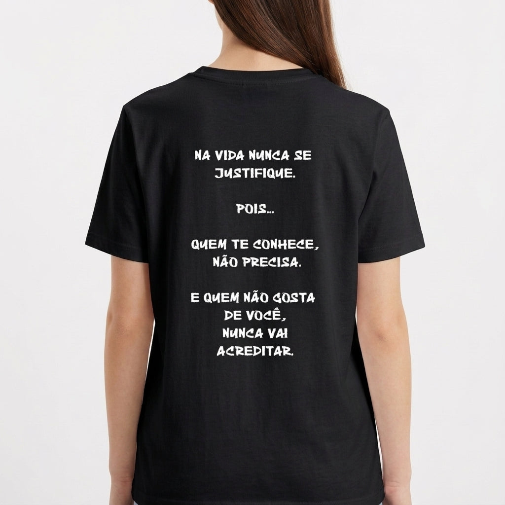 Camiseta com estampa frontal de assinatura estilizada e estampa traseira de frase motivacional em letras maiúsculas, dispostas em quatro linhas.