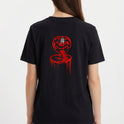 Camiseta com estampa frontal de texto estilizado "No Mercy Club" com efeito de gotejamento e estampa traseira de cobra ameaçadora também com gotejamento.