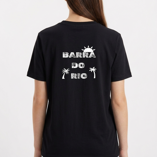 Camiseta com estampa frontal de cena litorânea com pessoas e jipe sobre balsa em rio, e estampa traseira de texto "Barra do Rio" com sol e palmeiras.