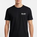 Camiseta com estampa frontal de texto estilizado pequeno no peito e estampa traseira de grande texto artístico com efeito de respingos e escorridos.