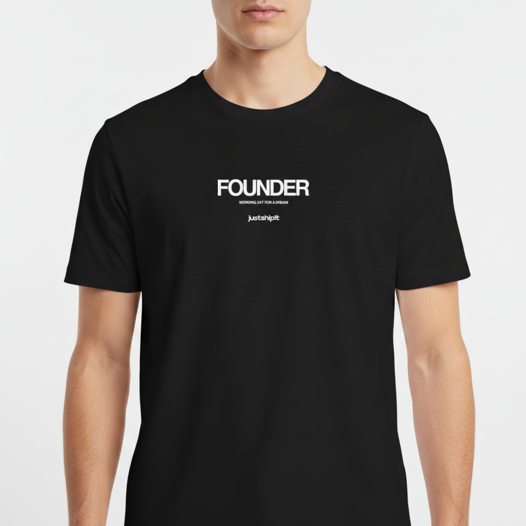 Camiseta com estampa frontal de texto "FOUNDER" em destaque, acompanhada pela frase "WORKING 24/7 FOR A DREAM" e logotipo "justshipit" abaixo.