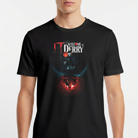 Camiseta com estampa frontal de texto "Welcome to Derry" acima de um balão flutuante, com silhuetas refletidas em um fundo iluminado.