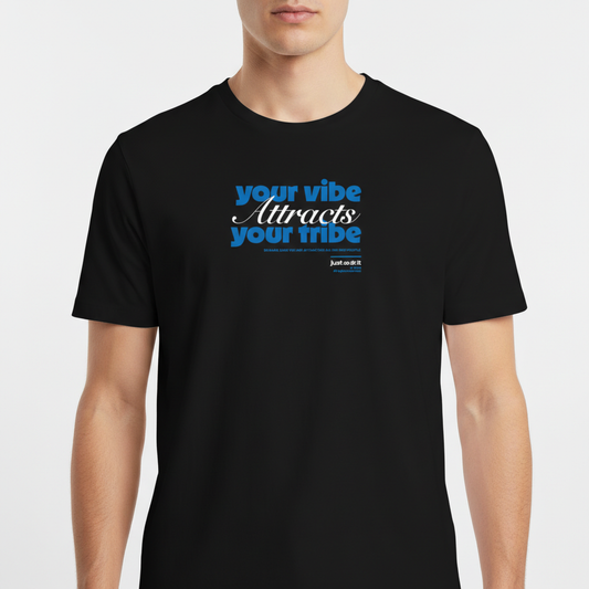 Camiseta com estampa frontal de frase inspiradora em fontes diversas, destacando "your vibe attracts your tribe," com pequenos detalhes textuais adicionais.