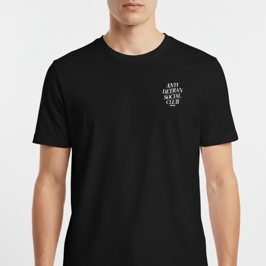 Camiseta com estampa frontal de escrita "ANTI DETRAN SOCIAL CLUB" e estampa traseira maior com a mesma mensagem, acompanhada por "NO BREAK STUDIOS".