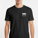 Camiseta com estampa frontal de um selo estilo rótulo de produto com os dizeres "ALTO EM ANSIEDADE", incluindo ilustração de uma lupa.