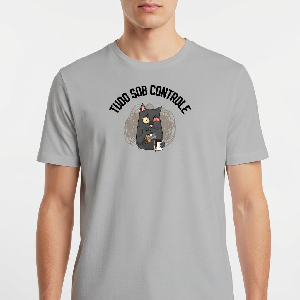 Camiseta com estampa frontal de um gato segurando uma caneca, acompanhado de uma expressão curiosa, envolto por linhas espirais e a frase "TUDO SOB CONTROLE".