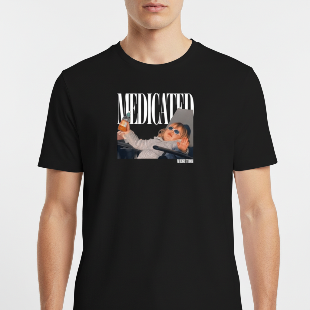 Camiseta com estampa frontal de fotografia de bebê com óculos escuros segurando uma mamadeira, acompanhada da palavra "MEDICATED" em letras grandes.