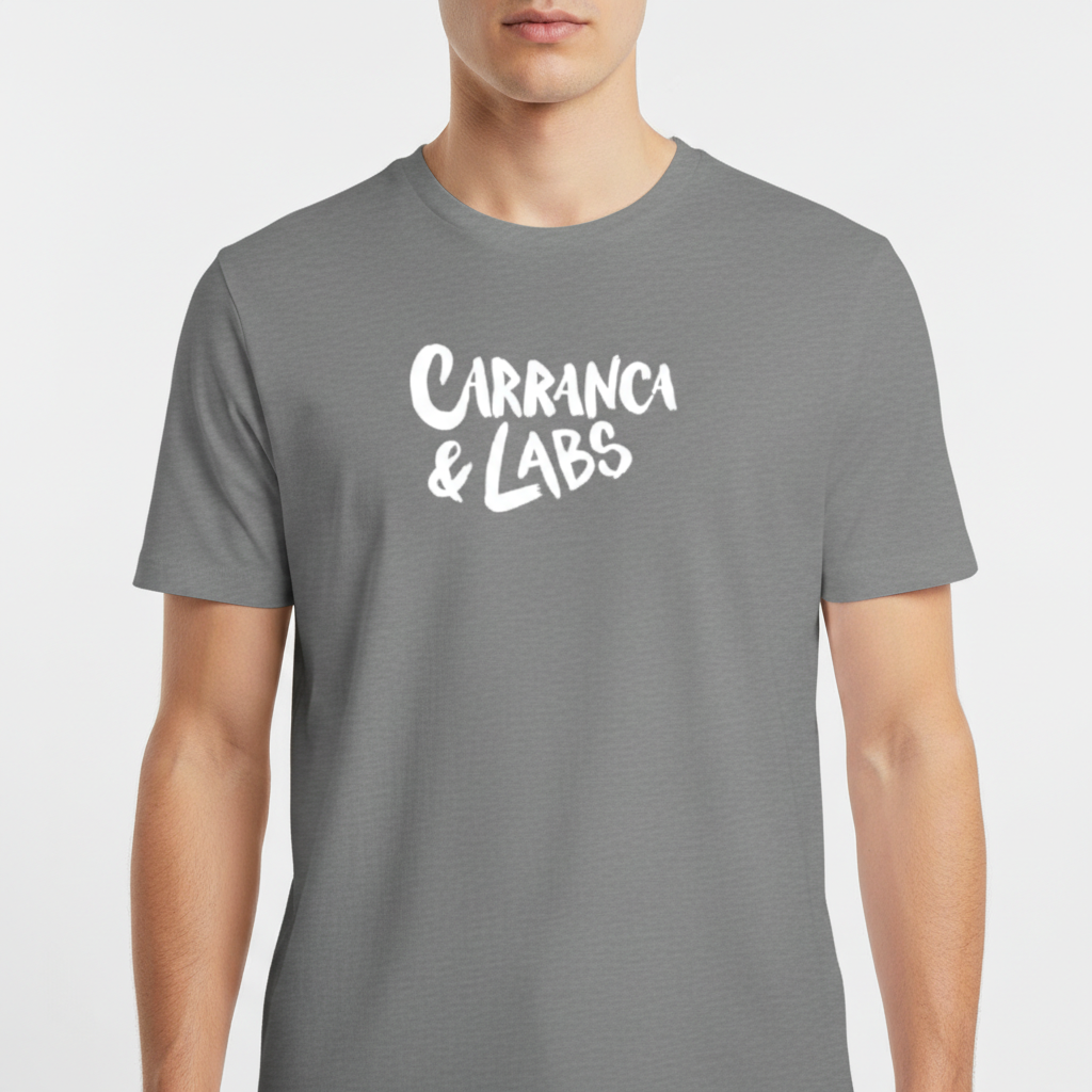 Camiseta com estampa frontal de letras estilizadas "Carranca & Labs" e estampa traseira de um desenho gráfico de figura caricata com expressão marcante.