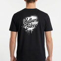 Camiseta com estampa frontal de texto estilizado pequeno no peito e estampa traseira de grande texto artístico com efeito de respingos e escorridos.