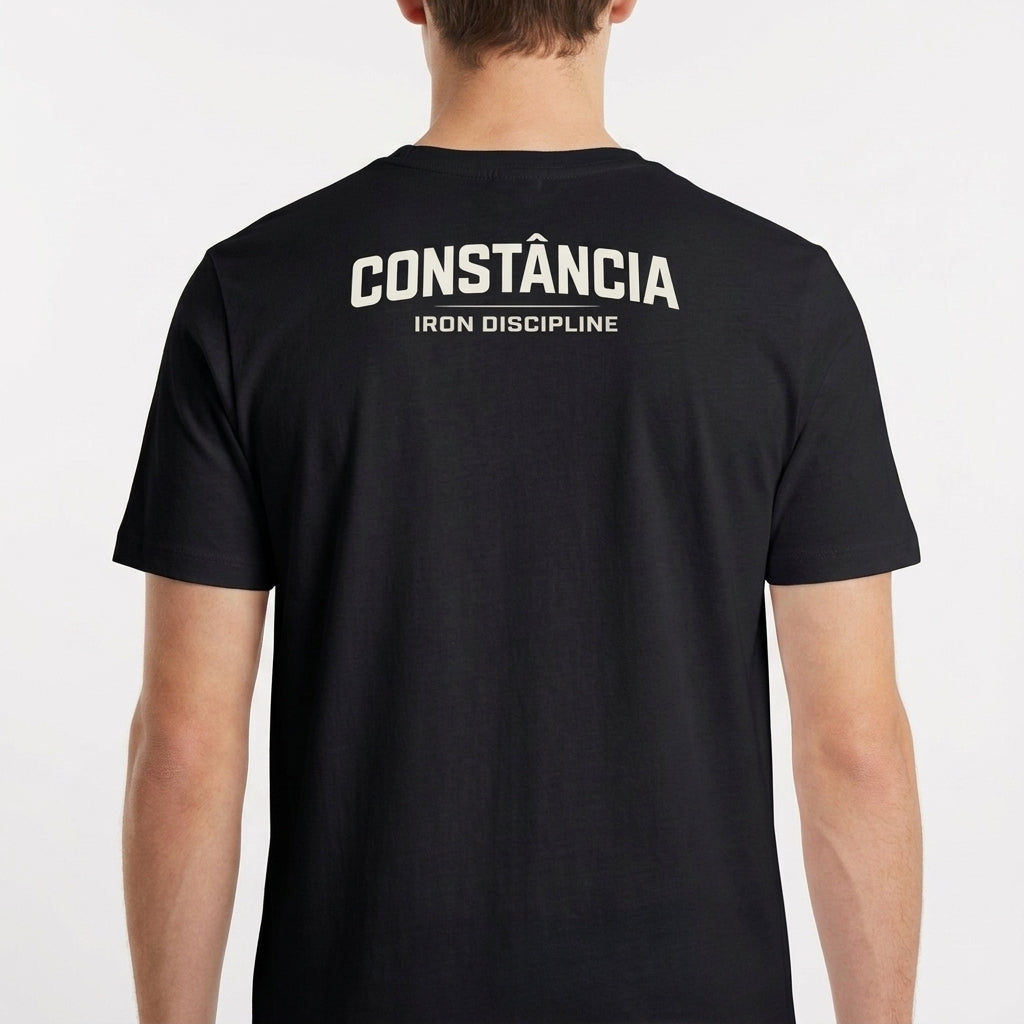 Camiseta com estampa frontal de "Iron Discipline" e design de montanhas, e estampa traseira de "CONSTÂNCIA Iron Discipline" em letras destacadas.