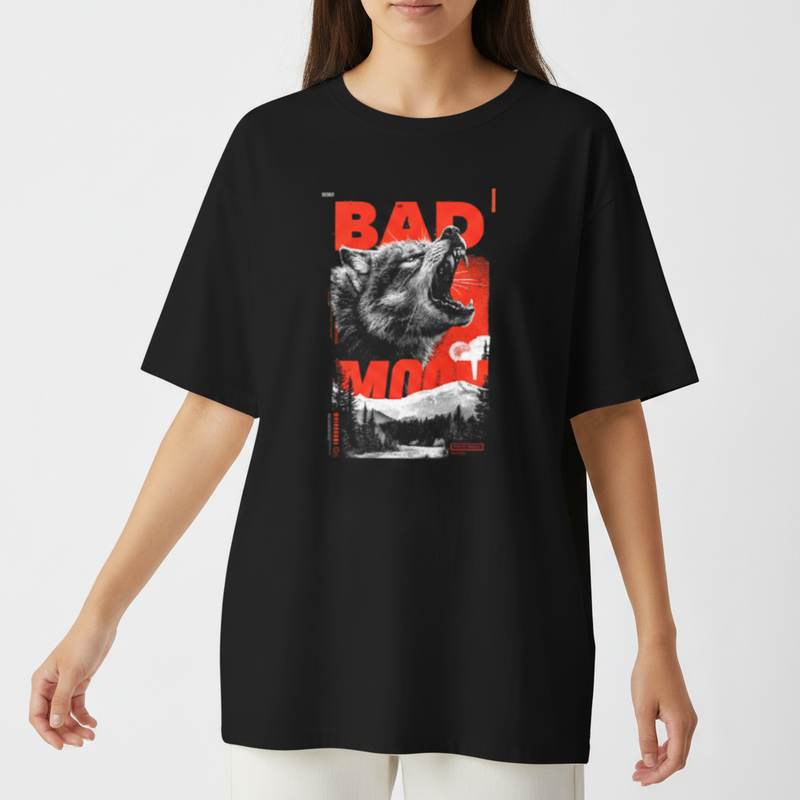 Camiseta com estampa frontal de um lobo uivante sobreposto a letras maiúsculas "BAD MOON", em contraste com uma paisagem de floresta ao fundo.