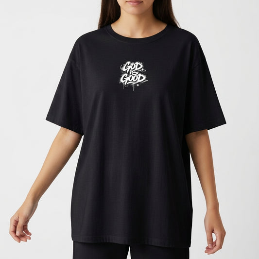 Camiseta com estampa frontal de lettering estilizado "God is Good" e estampa traseira de ilustração de anjo com a palavra "Justice" e detalhes de texto.